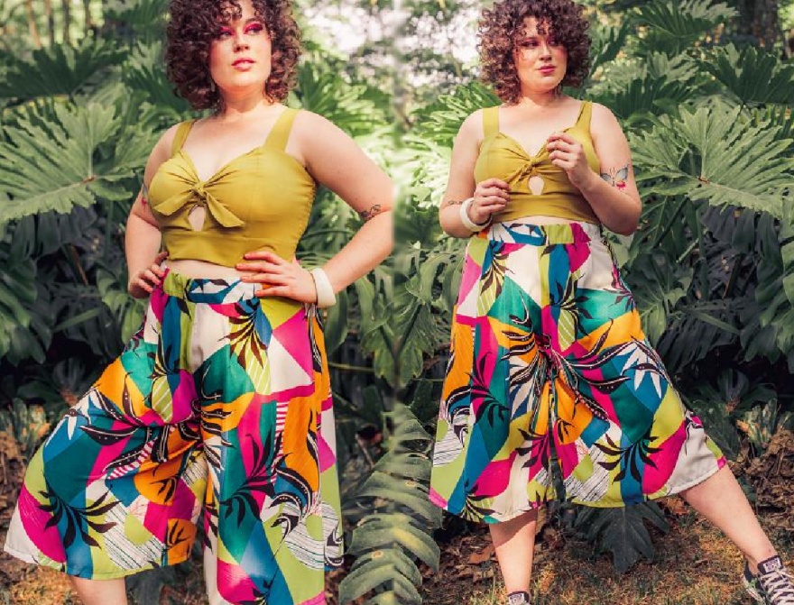 летние тренды 2020 для пышек - фото модного образа юбка-брюки с тропическим принтом в комплекте с кроп-топом горчичного цвета с бантом на груди