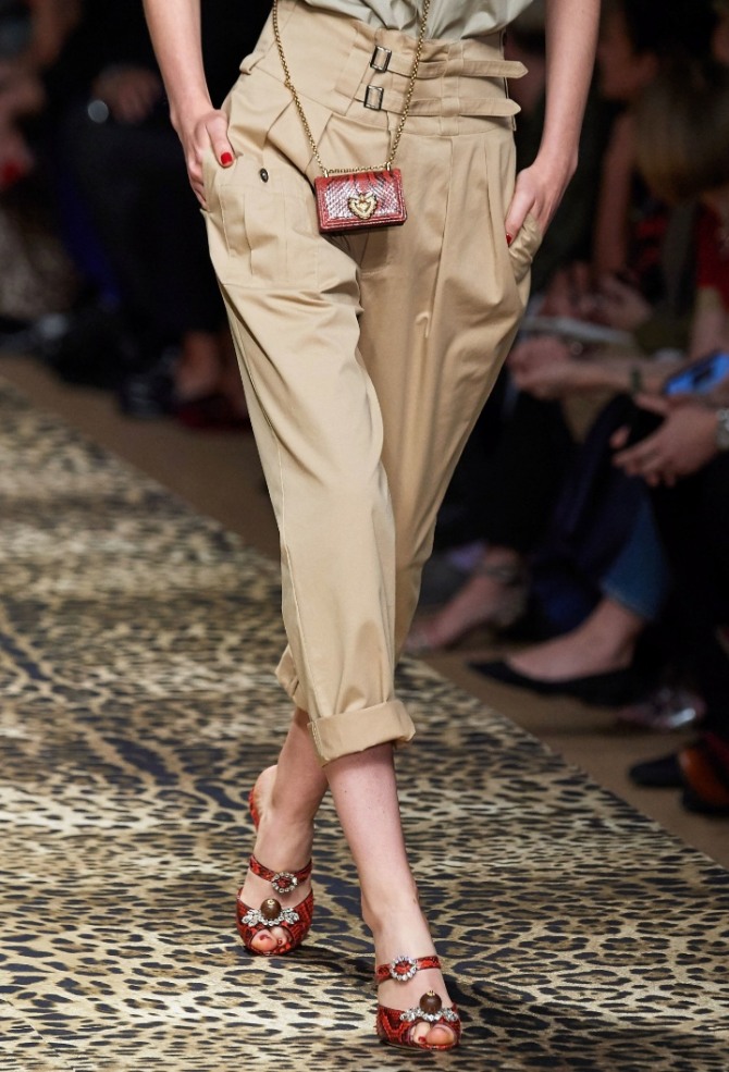 женские брюки-бананы песочного цвета с широким поясом и ремешками на высокой талии в комплекте с босоножками и сумочкой-малюткой - новинки с показов весна-лето 2020 от бренда Dolce & Gabbana