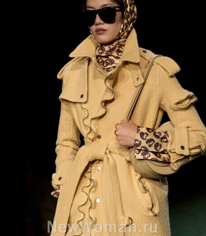 бежевое буклированное шерстяное пальто-тренчкот с декором из оборок и металлических молний
